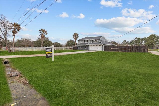 exterior space with driveway, fence, and a front lawn