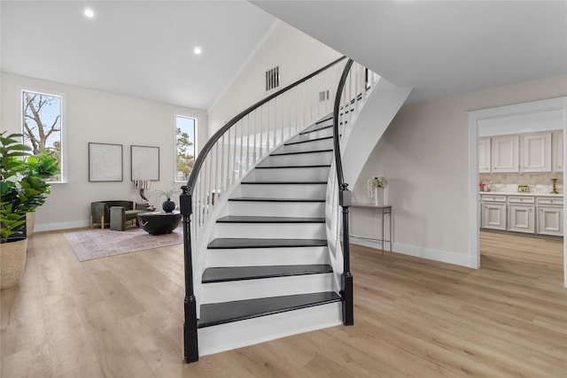 staircase featuring recessed lighting, visible vents, vaulted ceiling, wood finished floors, and baseboards