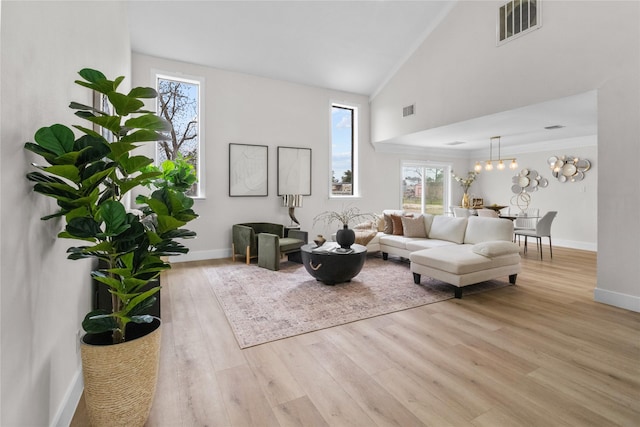 living room featuring a healthy amount of sunlight, visible vents, and light wood-style flooring