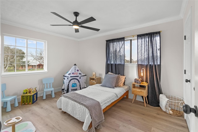 bedroom featuring crown molding, baseboards, a ceiling fan, and light wood-style floors