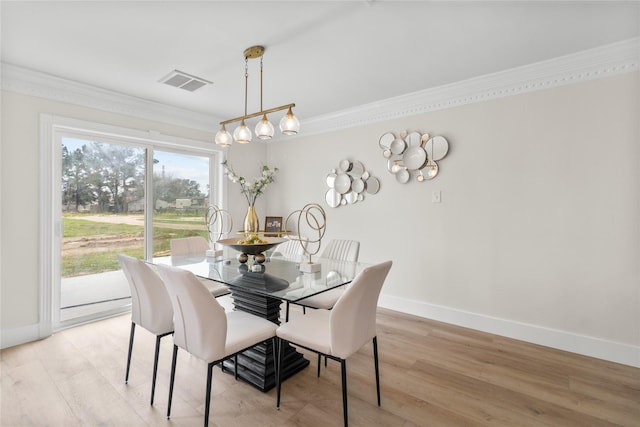 dining space featuring ornamental molding, visible vents, light wood-style flooring, and baseboards