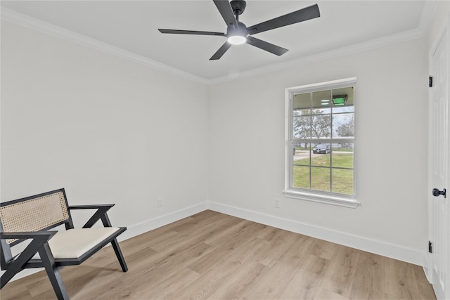 sitting room featuring light wood-style floors, baseboards, and ornamental molding