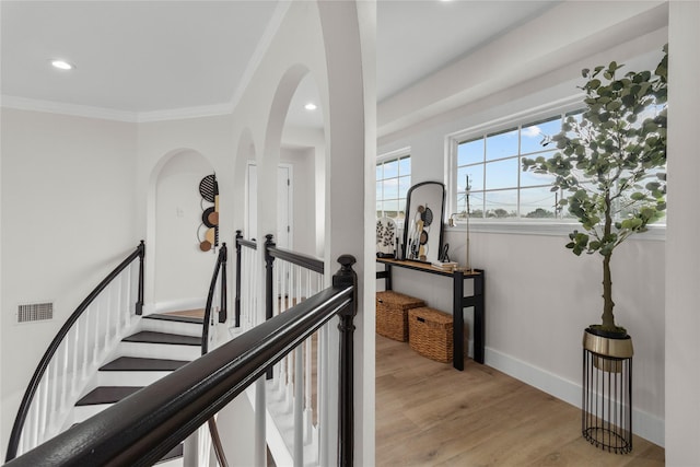 hallway featuring recessed lighting, visible vents, baseboards, ornamental molding, and light wood-type flooring