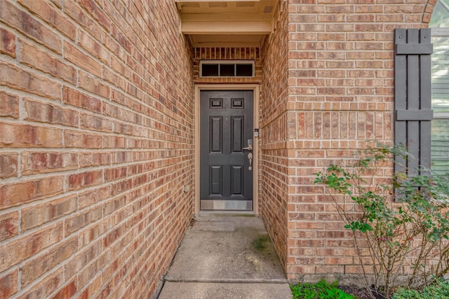 property entrance featuring brick siding