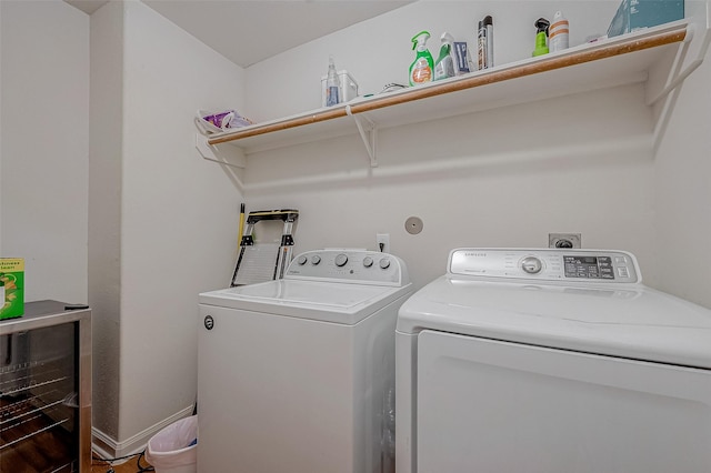 washroom with laundry area, washing machine and dryer, and baseboards