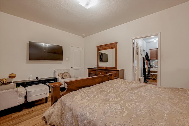 bedroom featuring a textured ceiling and light wood finished floors