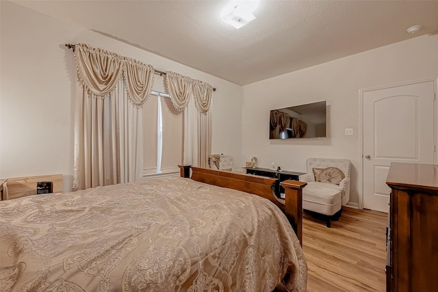 bedroom with light wood-style flooring and a textured ceiling