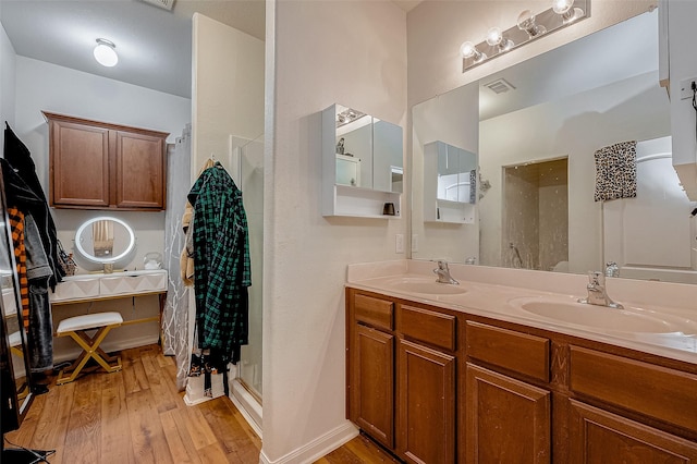 bathroom featuring wood finished floors, a sink, and visible vents