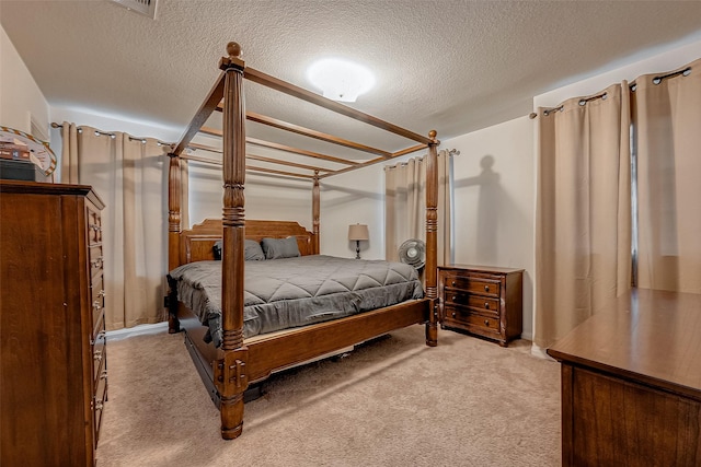 bedroom featuring light carpet and a textured ceiling