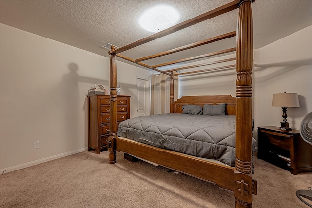 bedroom with a textured ceiling, carpet, visible vents, and baseboards