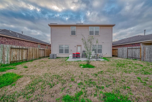 back of property featuring a fenced backyard, central AC unit, a lawn, and a patio