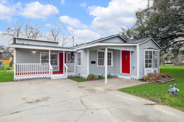 view of front facade with covered porch, concrete driveway, and a front yard