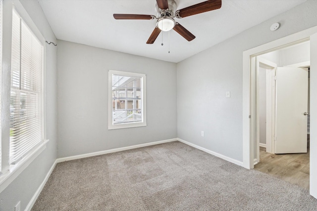 unfurnished room featuring light carpet, baseboards, and a wealth of natural light