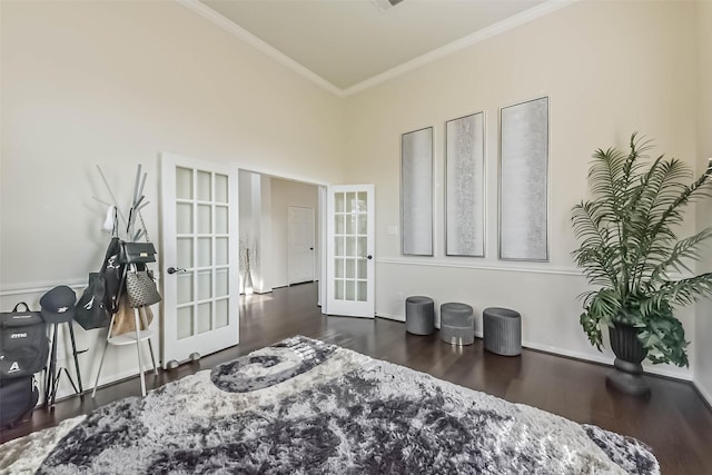 bedroom with a towering ceiling, dark wood-style flooring, crown molding, and french doors