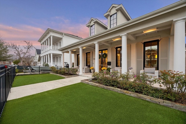 exterior space with a front yard, fence, and a balcony