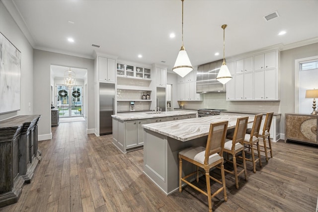 kitchen featuring a large island, backsplash, ornamental molding, dark wood-type flooring, and high quality appliances