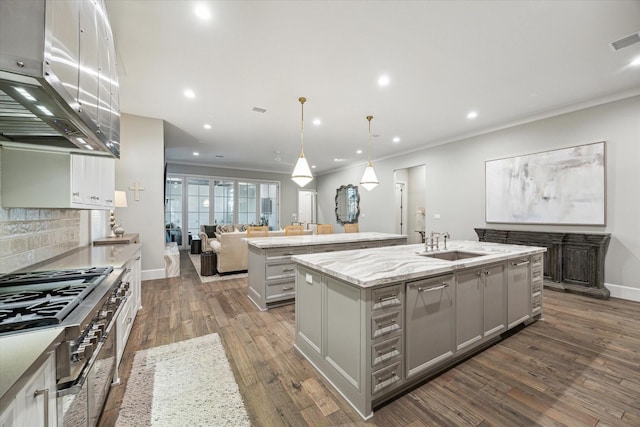 kitchen featuring a kitchen island with sink, gray cabinetry, a sink, visible vents, and open floor plan