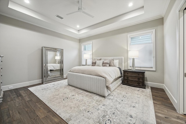 bedroom featuring dark wood-style floors, a raised ceiling, and visible vents