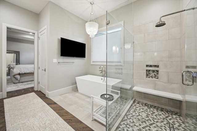 ensuite bathroom with a stall shower, ensuite bath, baseboards, and a soaking tub