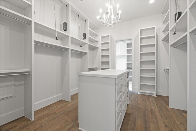 spacious closet featuring an inviting chandelier and dark wood-style flooring