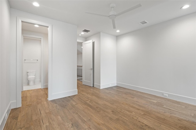 unfurnished bedroom with baseboards, visible vents, connected bathroom, wood finished floors, and recessed lighting