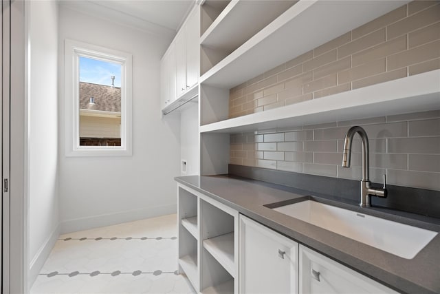 interior space featuring baseboards and a sink