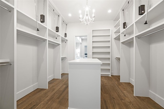 walk in closet featuring a chandelier and dark wood-type flooring