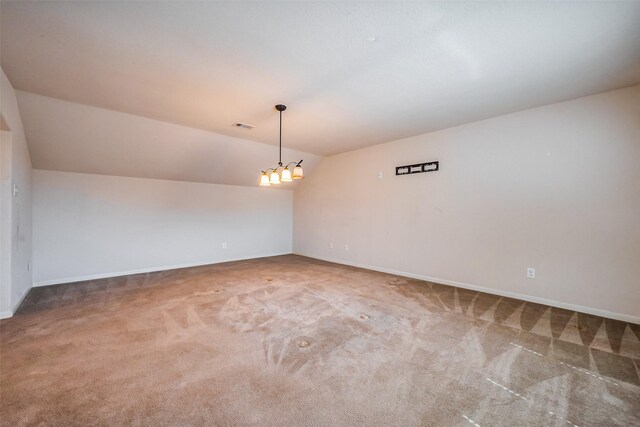 spare room with visible vents, lofted ceiling, baseboards, and carpet flooring