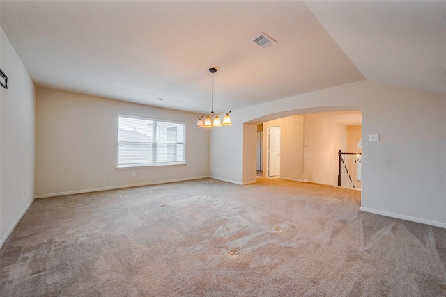 empty room with visible vents, vaulted ceiling, carpet flooring, arched walkways, and a notable chandelier