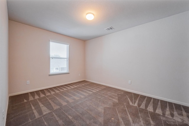 carpeted empty room with visible vents and baseboards