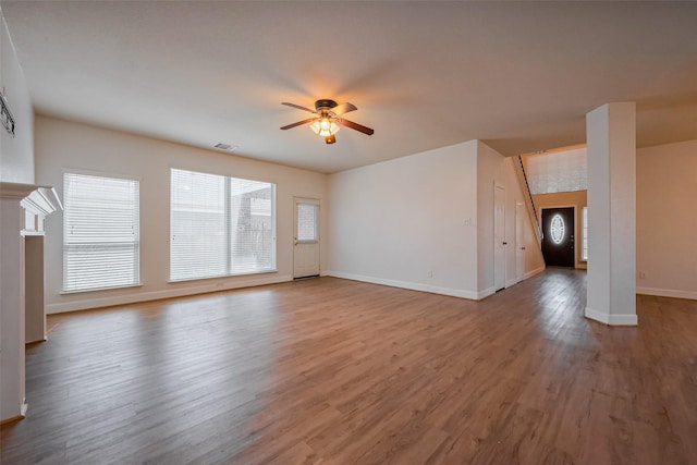 unfurnished living room with visible vents, baseboards, wood finished floors, and a ceiling fan