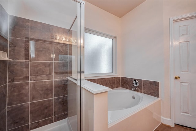 bathroom with a shower stall and a garden tub