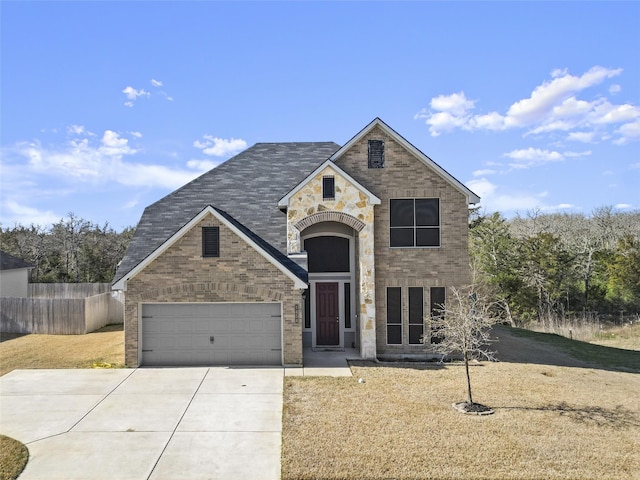 traditional-style house featuring a garage, concrete driveway, brick siding, and fence