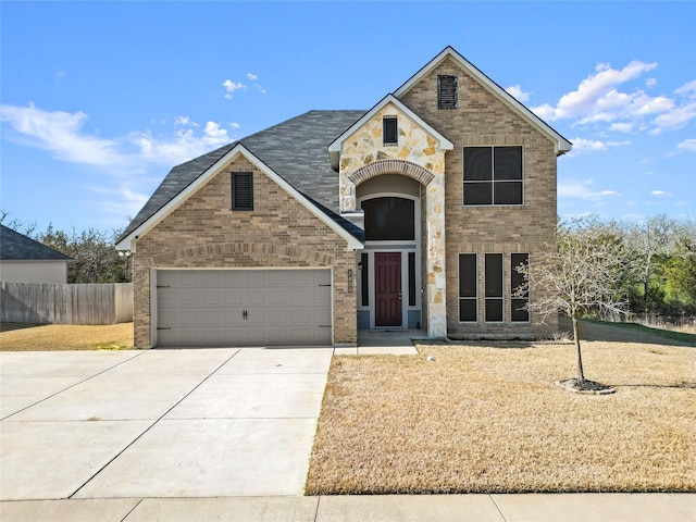 traditional-style home featuring a garage, driveway, brick siding, and fence