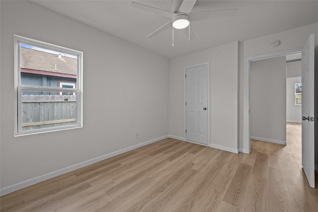 unfurnished bedroom featuring light wood finished floors, ceiling fan, and baseboards