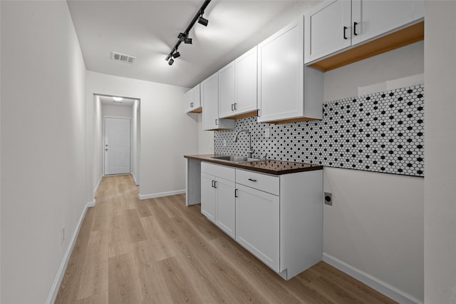 kitchen with visible vents, white cabinets, and a sink