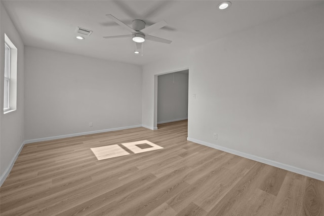 unfurnished room with baseboards, attic access, visible vents, and light wood-style floors