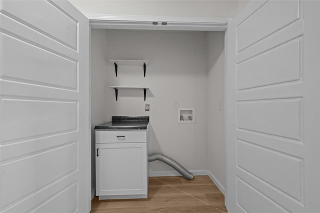 laundry area with light wood-style floors, washer hookup, cabinet space, and baseboards