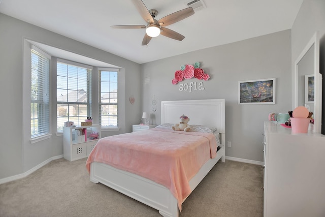 bedroom featuring baseboards, visible vents, a ceiling fan, and light colored carpet