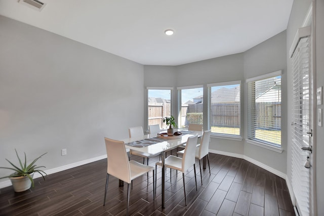 dining room featuring baseboards, a view of city, visible vents, and wood finish floors