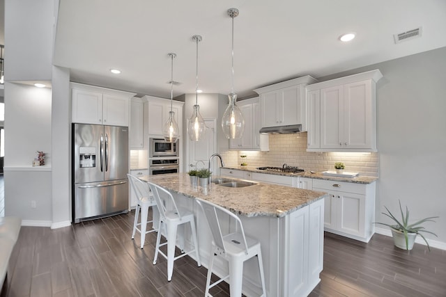 kitchen with white cabinetry, appliances with stainless steel finishes, pendant lighting, and a sink