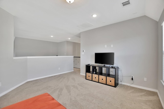 living area featuring lofted ceiling, baseboards, visible vents, and light colored carpet