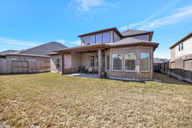 rear view of house with a fenced backyard, brick siding, a ceiling fan, a lawn, and a patio area