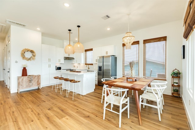 dining space with a chandelier, light wood-style flooring, visible vents, and recessed lighting