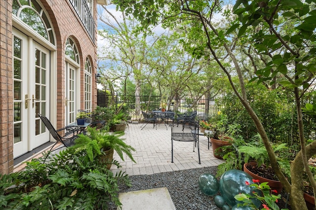 view of patio featuring outdoor dining space, french doors, and fence