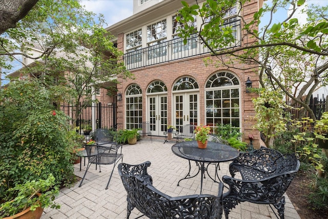 view of patio / terrace featuring french doors, outdoor dining area, and fence