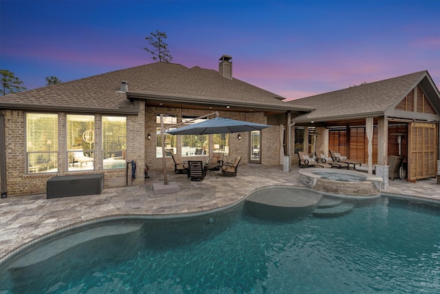 outdoor pool featuring a patio and an in ground hot tub