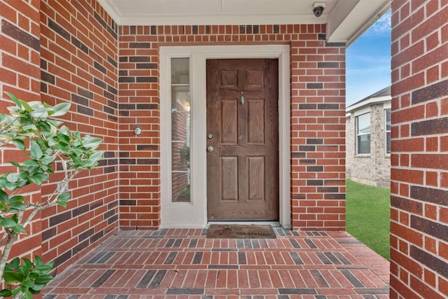 view of exterior entry with brick siding