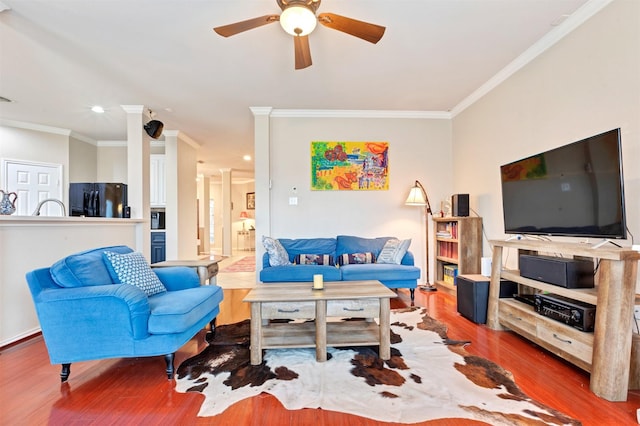 living area with a ceiling fan, crown molding, and wood finished floors