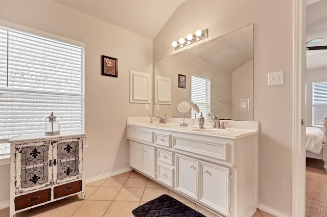 ensuite bathroom featuring double vanity, lofted ceiling, a sink, ensuite bath, and tile patterned flooring